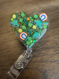 St Patrick heart badge reel, green heart badge, st Patty badge, lucky charm badge, March badge, glitter badge, four leaf clover badge