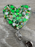St Patrick heart badge reel, green heart badge, st Patty badge, lucky charm badge, March badge, glitter badge, four leaf clover badge